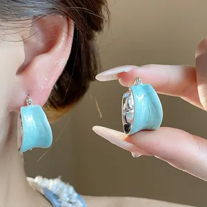 Dettaglio orecchini a cerchio minimalisti in smalto azzurro placcati in oro 18 carati