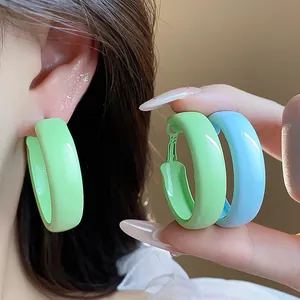 Macro detail of glossy dopamine style spray painted hoop earrings in green and blue