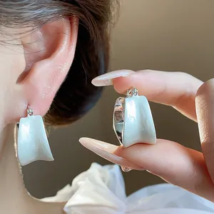 Primo piano della trama degli orecchini in smalto bianco con placcatura in oro 18k