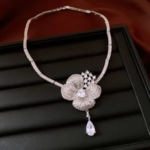 Detailed macro view of a silver-toned flower necklace with zirconia and teardrop crystal