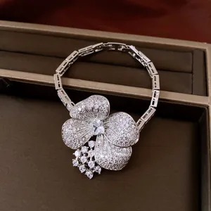 Close-up detail of silver zircon flower pendant necklace on a luxury jewelry box