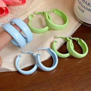 Macro detail of dopamine style hoop earrings in pastel blue and green finishes