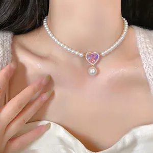 Detailed macro view of French vintage pearl necklace with a pink heart zircon pendant