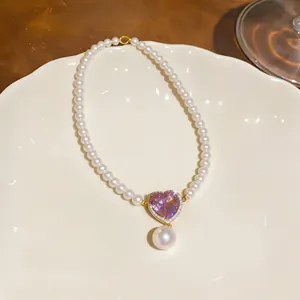 Exquisite close-up of pearl necklace with heart-shaped purple zircon and a pearl drop