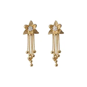 Eleganti orecchini a fiore placcati in oro 18 carati con nappe di perline su sfondo bianco.