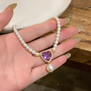 Close-up of French vintage pearl necklace with purple heart zircon pendant and drop pearl