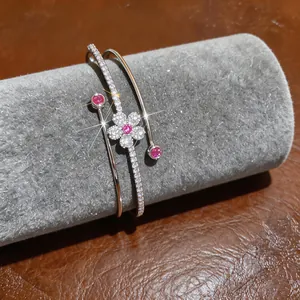 Close-up of a silver-tone flower bangle with sparkling pink and clear zircons on display