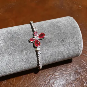 Detail of butterfly motif on silver bracelet with red and white sparkling zircons