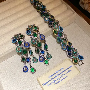 Detailweergave van gekleurde kwastjes oorbellen met druppelstenen en bijpassende armband set