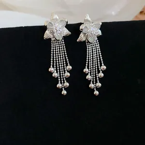 Eleganti orecchini a nappa a fiore placcati oro 18k con zirconi su velluto nero