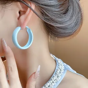 Detailed close-up showing light blue matte painted hoop earring worn by a model
