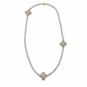 Elegant silver beaded necklace featuring three gold-tone flower charms with sparkling zirconia