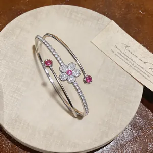 Close-up of elegant silver flower bangle with pink zircons and refined detailing
