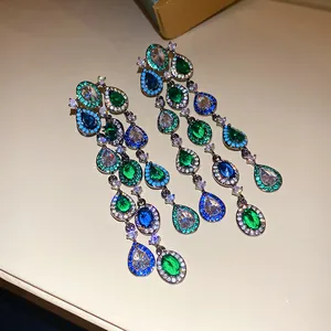 Gedetailleerde weergave van elegante kwastjesoorbellen met groene en blauwe zirkonia druppels.