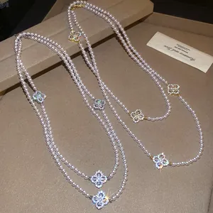 Detailed view of double-layer pearl necklace with sparkling zircon flower charms
