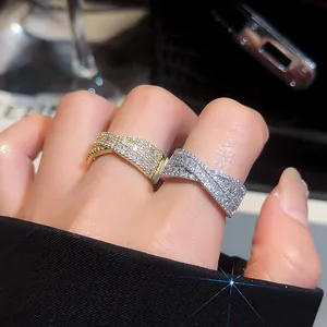 Vue détaillée de bagues ouvertes croisées en X avec un pavé de zircons étincelants.