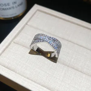 Gros plan d'une bague croisée en argent sertie de pierres scintillantes