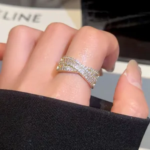 Gros plan détaillé d'une bague dorée en forme de X croisé avec pavé de zircons