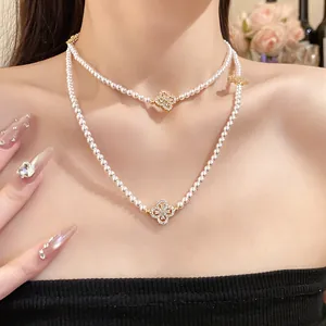 Detail shot of a double-layered pearl necklace with sparkling zircon flower pendants