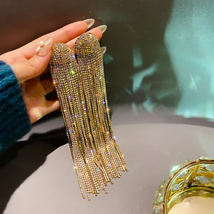 Detailed view of luxury gold-toned tassel earrings with shimmering crystals.
