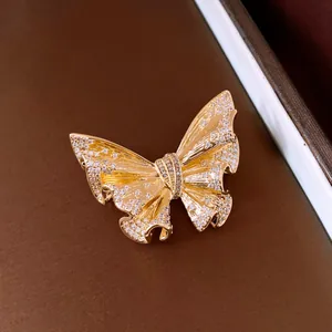 Macro detail of 18k gold-plated butterfly brooch featuring exquisite crystal pavé settings