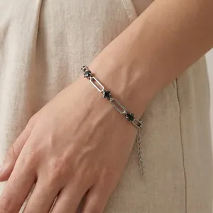 Close-up of stainless steel paperclip bracelet with black rhombus zirconia on wrist.