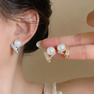 Elegant close-up of French style pearl and baguette zircon earrings in gold and silver