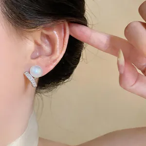 Detailed view of elegant French style earrings featuring a large pearl and zircon accents