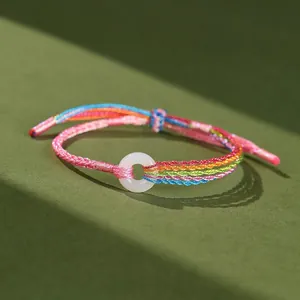 Dettaglio macro di un braccialetto intrecciato a mano colorato con fibbia in giada
