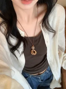 Detail of Korean style round pleated resin pendant on brown leather cord necklace