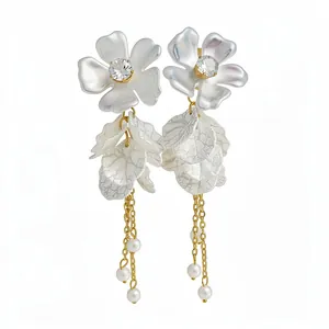 Elegant white acrylic flower earrings with delicate gold chains and small pearls
