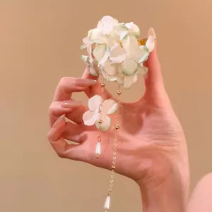 Elegant fabric flower petal hair clip with long tassel and pearl drops in hand view