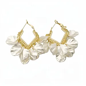 Boucles d'oreilles créoles style français avec pétales de fleurs blanches et détails dorés.