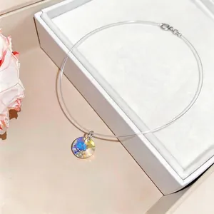 Elegant stainless steel necklace with circular iridescent crystal pendant on clear cord