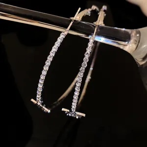 Vista macro di eleganti orecchini a cerchio in argento con strass scintillanti e stelle.