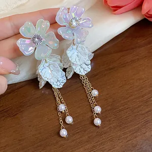 Detailed close-up view of elegant acrylic flower earrings with pearl tassels and silver posts