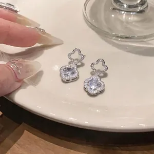 Silver flower stud earrings with sparkling cubic zirconia stones in a hollow design