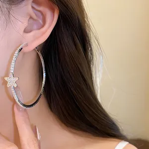 Primo piano dettagliato di un orecchino a cerchio con stella di strass lucenti