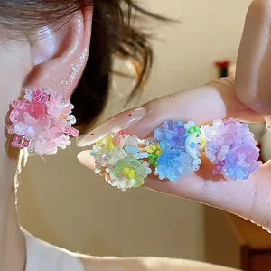 Gros plan de boucles d'oreilles en perles de verre colorées en forme de fleur tendance