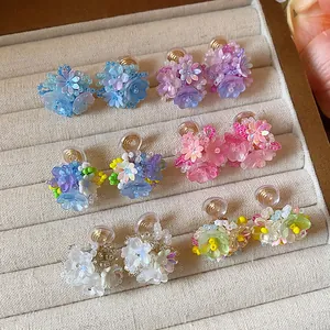 Gros plan de boucles d'oreilles fleurs en perles faites main sur plateau en velours