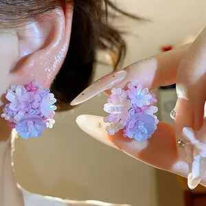 Vue détaillée de boucles d'oreilles fleurs en perles de verre violettes et bleues