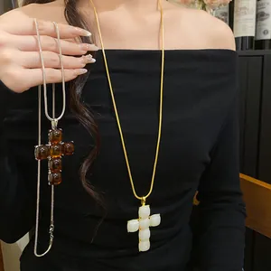 Elegant resin cross pendant necklaces in amber and cream white finishes