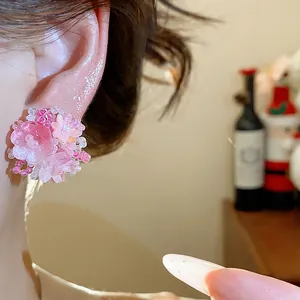 Gros plan détaillé des boucles d'oreilles fleurs en perles roses pour un look élégant