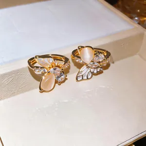 Vue détaillée de boucles d'oreilles papillon dorées avec œil de chat et zircons