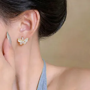 Détail exquis d'une boucle d'oreille papillon en or avec zircon et pierre œil de chat
