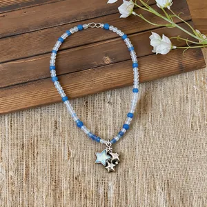 Primer plano detallado de un collar de cuentas estilo playa con colgante de estrella azul