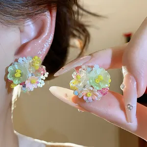 Gros plan sur les boucles d'oreilles fleurs en perles de verre colorées de style