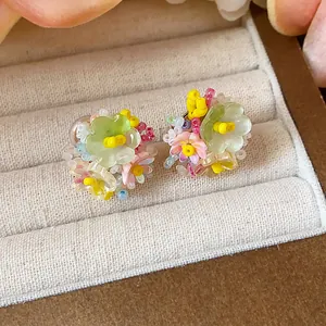 Gros plan détaillé de boucles d'oreilles fleurs en perles de verre colorées
