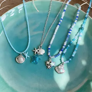 Primer plano de collares de cuentas hechos a mano con colgantes de concha y estrella de mar