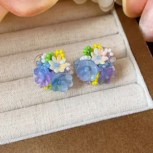 Vue macro détaillée de boucles d'oreilles fleurs en perles de verre colorées faites main